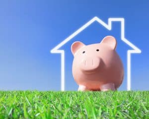 Piggy bank in imaginary house representing home building costs
