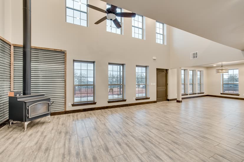Barndominium great room with a double-height ceiling, corrugated metal accent wall and clerestory windows