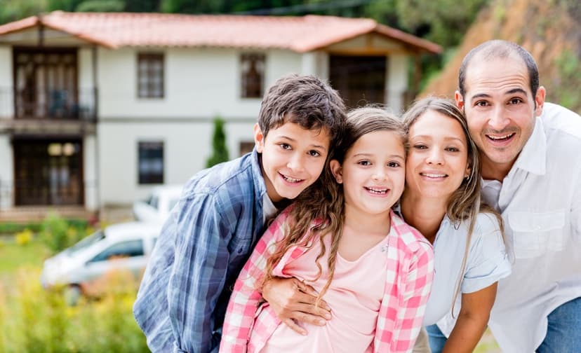 Happy family outside their house in the countryside