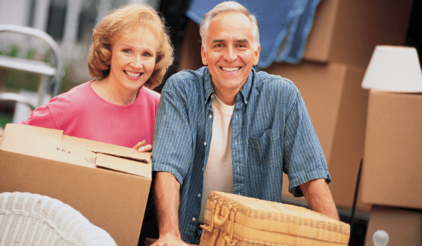 older couple carrying moving boxes