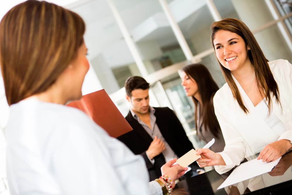 Woman doing check-in at a hotel and paying by credit cad