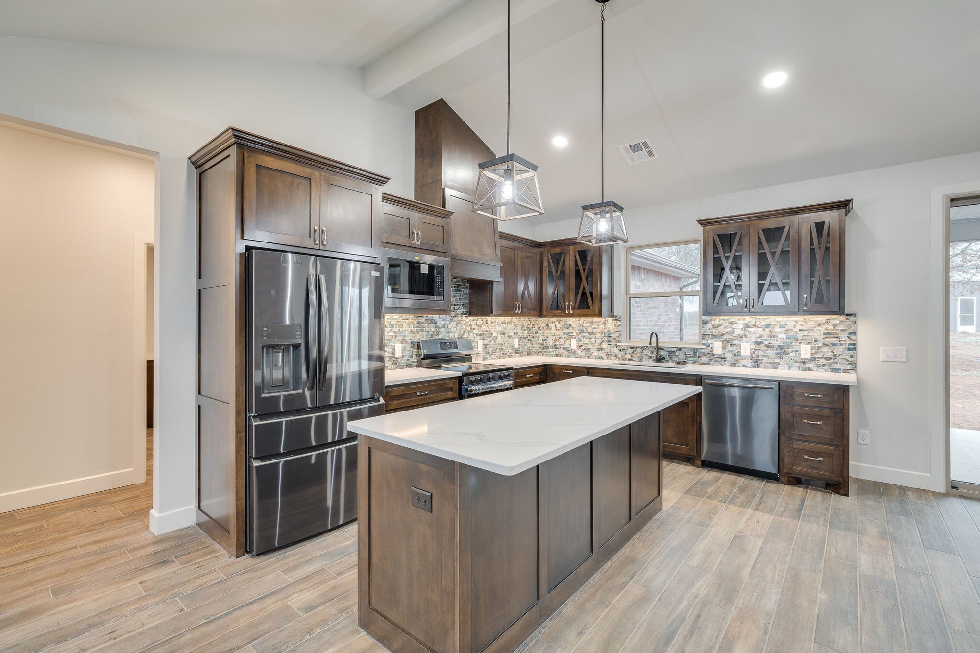 Luxury kitchen design with pendant lighting, quartz countertops, and farmhouse finishes in Blanchard Oklahoma custom home