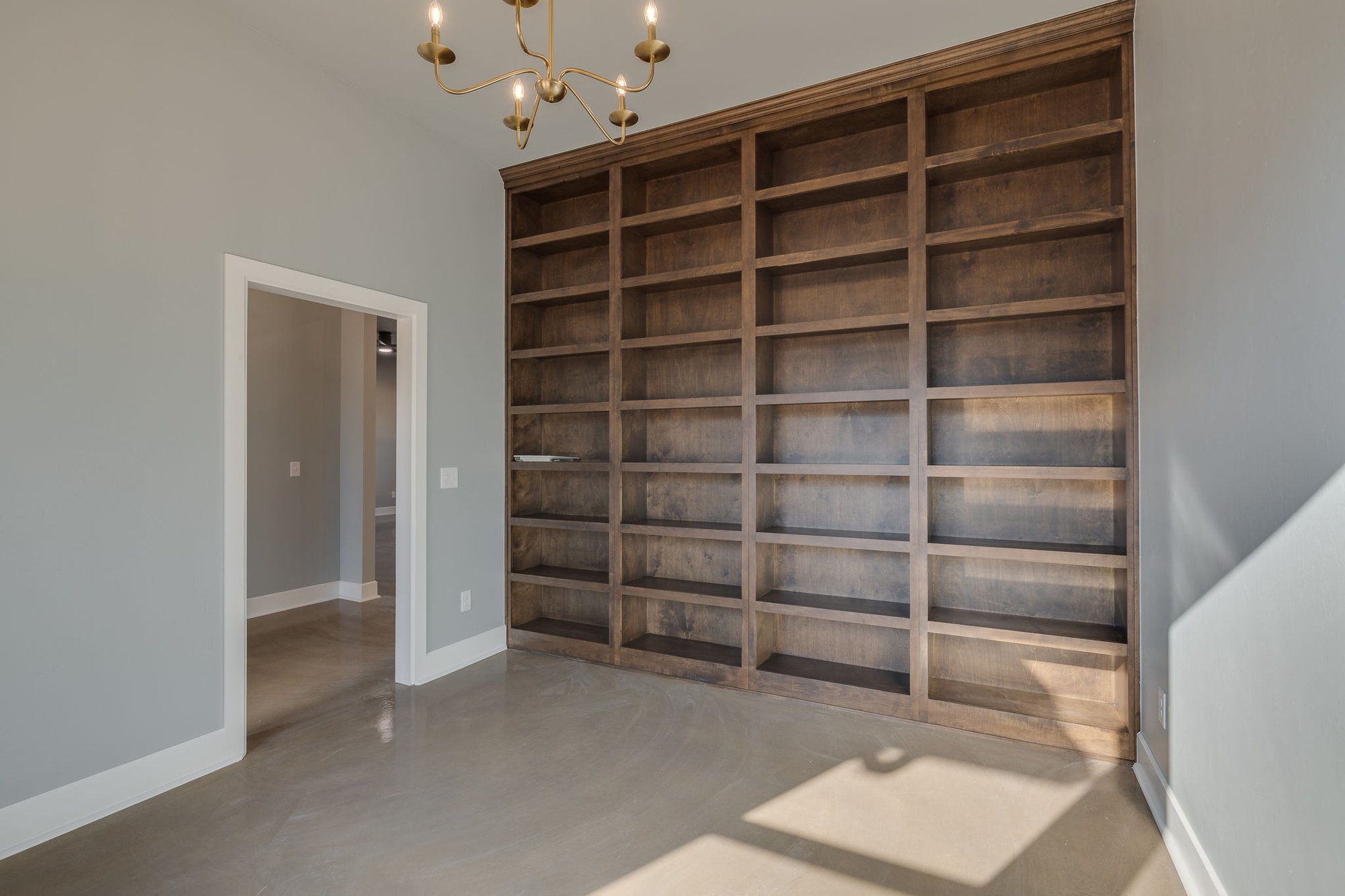Home office design with wall-to-wall shelving in Tecumseh Oklahoma custom home builder project