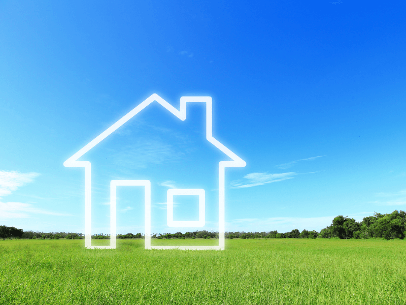 Outline of a house against a grassy field and blue sky.