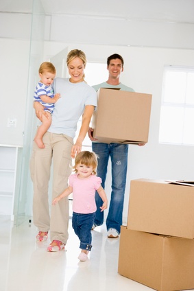 Family with box moving into new home smiling