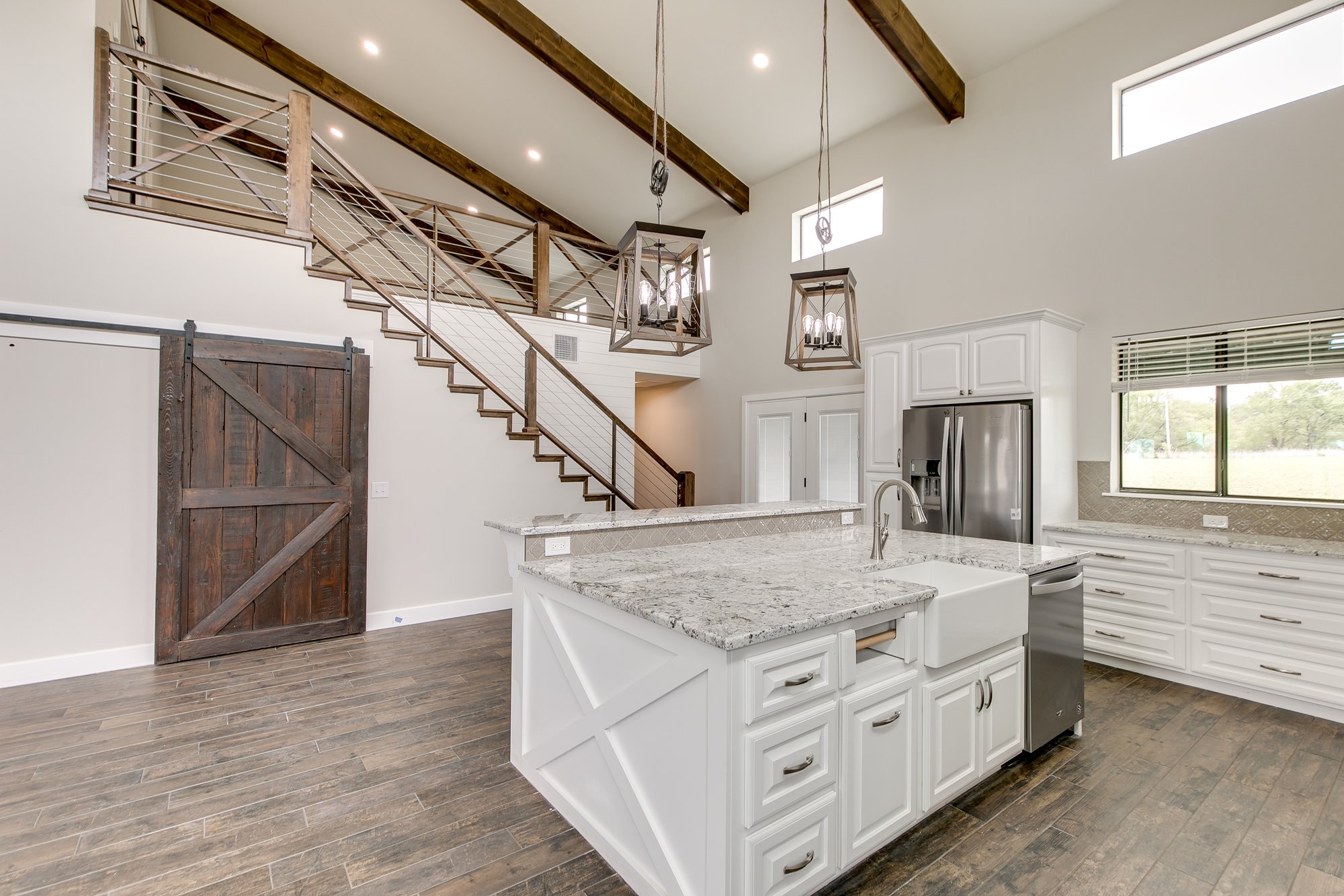 Modern barndominium interior featuring large island and rustic design by Newcastle Oklahoma custom home builder