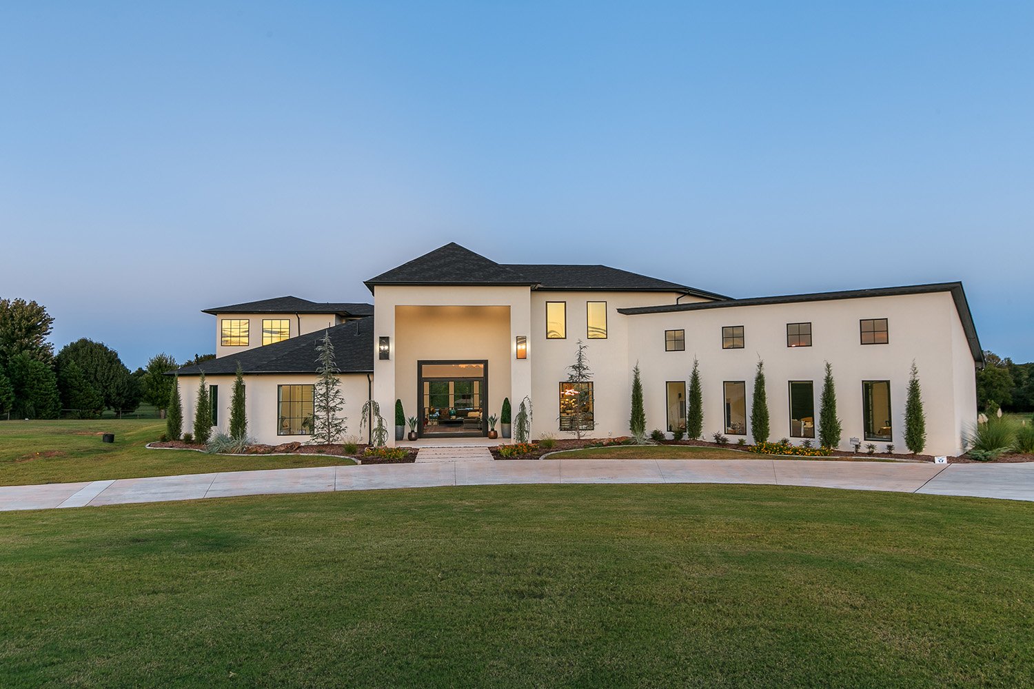 Contemporary stucco home in Oklahoma City with clean white exterior, black trim, and a grand modern entryway.