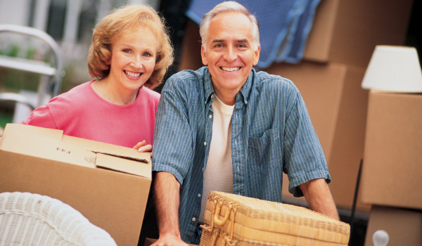 older couple carrying moving boxes